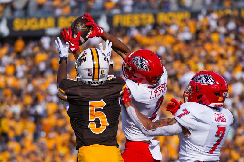 Sep 30, 2023; Laramie, Wyoming, USA; New Mexico Lobos cornerback Zach Morris (2) battles Wyoming Cowboys wide receiver Ayir Asante (5) for the ball during the second quarter at Jonah Field at War Memorial Stadium. Mandatory Credit: Troy Babbitt-USA TODAY Sports

