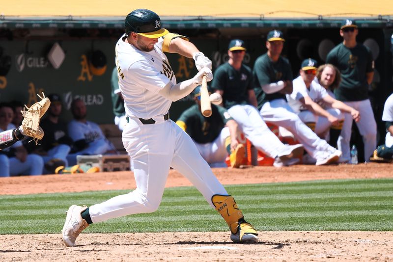 May 23, 2024; Oakland, California, USA; Oakland Athletics shortstop Max Shuemann (12) hits a RBI single against the Colorado Rockies during the seventh inning at Oakland-Alameda County Coliseum. Mandatory Credit: Kelley L Cox-USA TODAY Sports