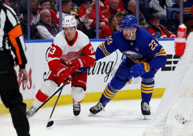 Dec 5, 2023; Buffalo, New York, USA;  Detroit Red Wings left wing Lucas Raymond (23) and Buffalo Sabres defenseman Mattias Samuelsson (23) go after a loose puck behind the net during the first period at KeyBank Center. Mandatory Credit: Timothy T. Ludwig-USA TODAY Sports