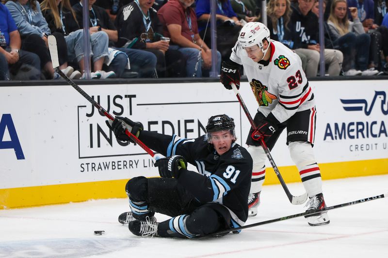 Oct 8, 2024; Salt Lake City, Utah, USA; Utah Hockey Club forward Josh Doan (91) skates against Chicago Blackhawks center Philipp Kurashev (23) during the second period at Delta Center. Mandatory Credit: Rob Gray-Imagn Images