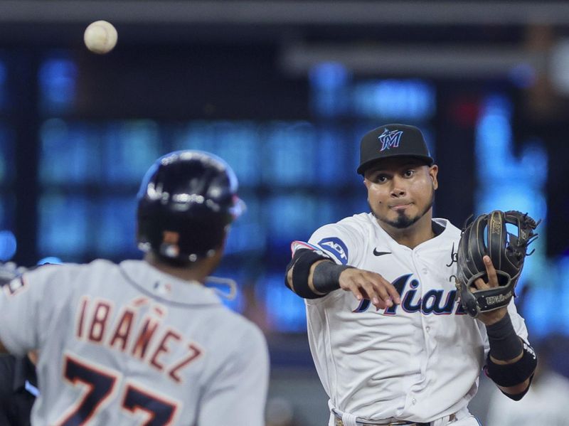 Jul 30, 2023; Miami, Florida, USA; Miami Marlins second baseman Luis Arraez (3) turns a double play as Detroit Tigers second baseman Andy Ibanez (77) slides at second base during the first inning at loanDepot Park. Mandatory Credit: Sam Navarro-USA TODAY Sports