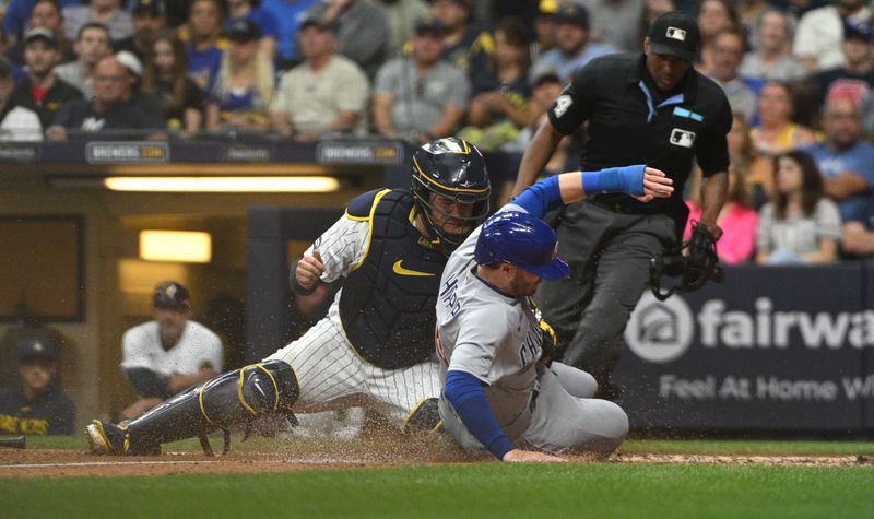 Sep 30, 2023; Milwaukee, Wisconsin, USA; Chicago Cubs left fielder Ian Happ (8) is tagged out by Milwaukee Brewers catcher Victor Caratini (7) in the fourth inning at American Family Field. Mandatory Credit: Michael McLoone-USA TODAY Sports