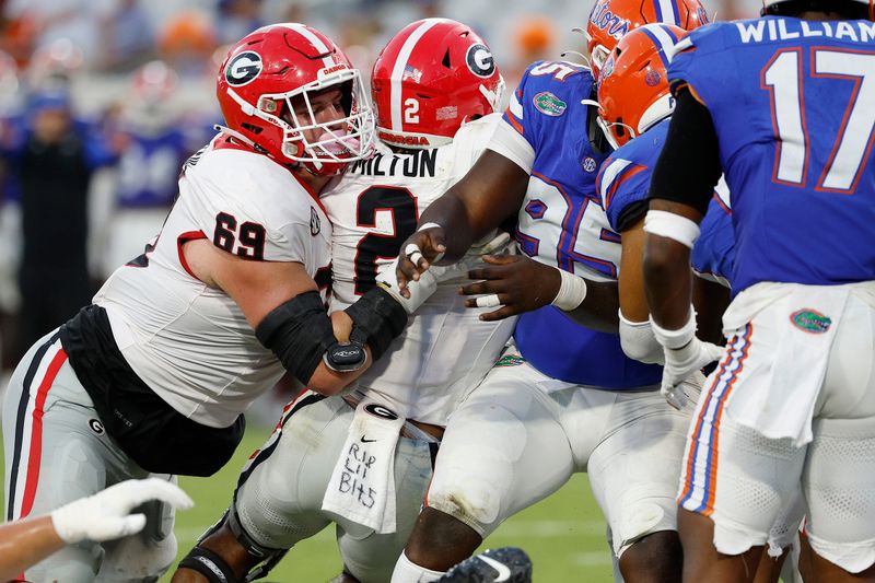 Oct 28, 2023; Jacksonville, Florida, USA; Georgia Bulldogs running back Kendall Milton (2) is pushed into the end zone by Georgia Bulldogs offensive lineman Tate Ratledge (69) in for a touchdown in the second half against the Florida Gators at EverBank Stadium. Mandatory Credit: Jeff Swinger-USA TODAY Sports