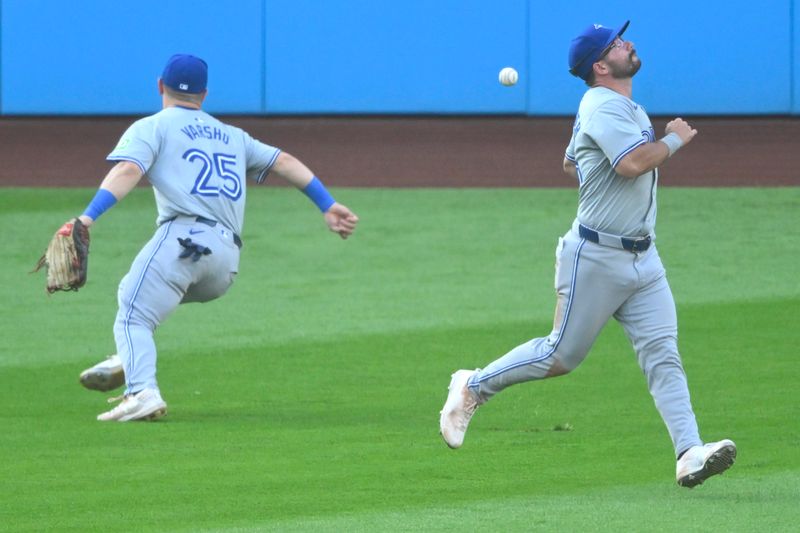 Jun 21, 2024; Cleveland, Ohio, USA; The ball gets by Toronto Blue Jays center fielder Daulton Varsho (25) and left fielder Davis Schneider (36) in the second inning against the Cleveland Guardians at Progressive Field. Mandatory Credit: David Richard-USA TODAY Sports