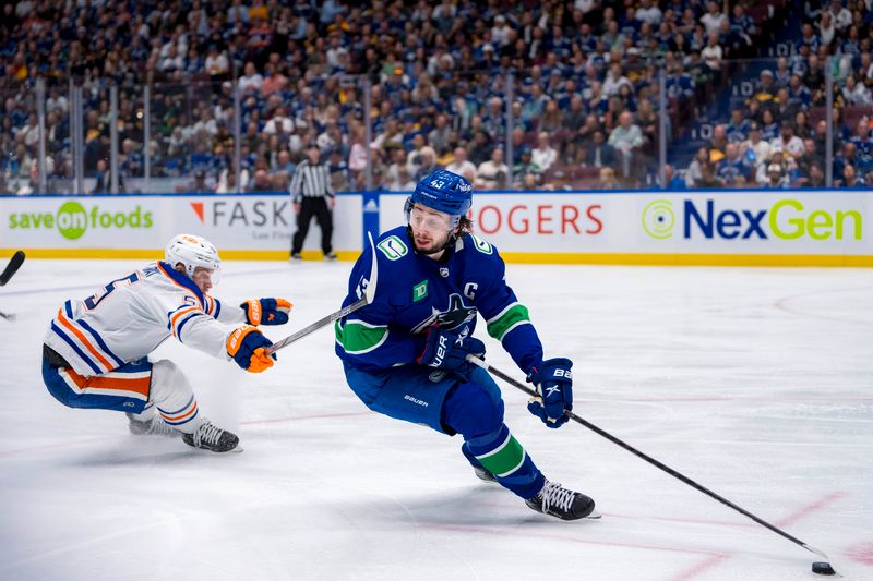 May 10, 2024; Vancouver, British Columbia, CAN; Edmonton Oilers forward Dylan Holloway (55) stick checks Vancouver Canucks defenseman Quinn Hughes (43) during the second period in game two of the second round of the 2024 Stanley Cup Playoffs at Rogers Arena. Mandatory Credit: Bob Frid-USA TODAY Sports