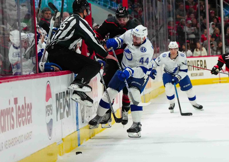 Nov 24, 2023; Raleigh, North Carolina, USA; Tampa Bay Lightning defenseman Calvin de Haan (44) checks Carolina Hurricanes left wing Jordan Martinook (48) during the first period at PNC Arena. Mandatory Credit: James Guillory-USA TODAY Sports