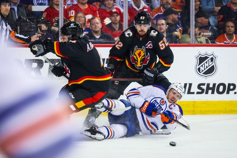 Apr 6, 2024; Calgary, Alberta, CAN; Edmonton Oilers center Connor McDavid (97) and Calgary Flames defenseman MacKenzie Weegar (52) battles for the puck during the third period at Scotiabank Saddledome. Mandatory Credit: Sergei Belski-USA TODAY Sports