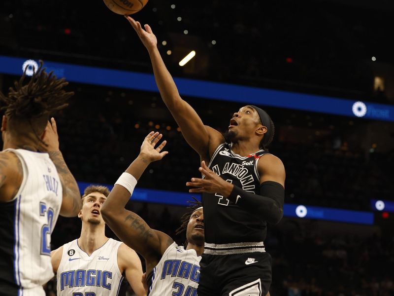 SAN ANTONIO, TX - MARCH 14: Devonte Graham #4 of the San Antonio Spurs goes to the basket past Wendell Carter Jr.#34 of the Orlando Magic in the first half at AT&T Center on March 14, 2023 in San Antonio, Texas. NOTE TO USER: User expressly acknowledges and agrees that, by downloading and or using this photograph, User is consenting to terms and conditions of the Getty Images License Agreement. (Photo by Ronald Cortes/Getty Images)