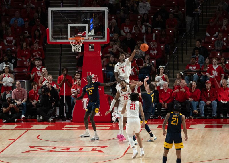 Jan 6, 2024; Houston, Texas, USA; West Virginia Mountaineers forward Quinn Slazinski (11) has his shot blocked by Houston Cougars forward Ja'Vier Francis (5) in the first half  at Fertitta Center. Mandatory Credit: Thomas Shea-USA TODAY Sports