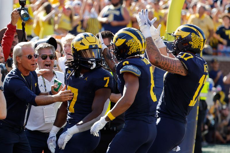 Sep 21, 2024; Ann Arbor, Michigan, USA;  Michigan Wolverines running back Donovan Edwards (7) receives congratulations from teammates after he rushes for a touchdown in the first half against the USC Trojans at Michigan Stadium. Mandatory Credit: Rick Osentoski-Imagn Images