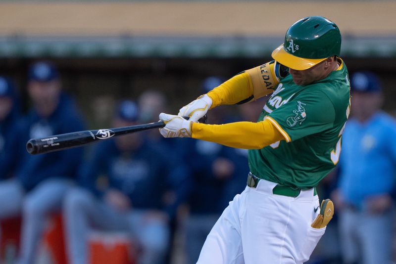 Aug 19, 2024; Oakland, California, USA; Oakland Athletics outfielder JJ Bleday (33) hits a two-run home run during the first inning against the Tampa Bay Rays at Oakland-Alameda County Coliseum. Mandatory Credit: Stan Szeto-USA TODAY Sports