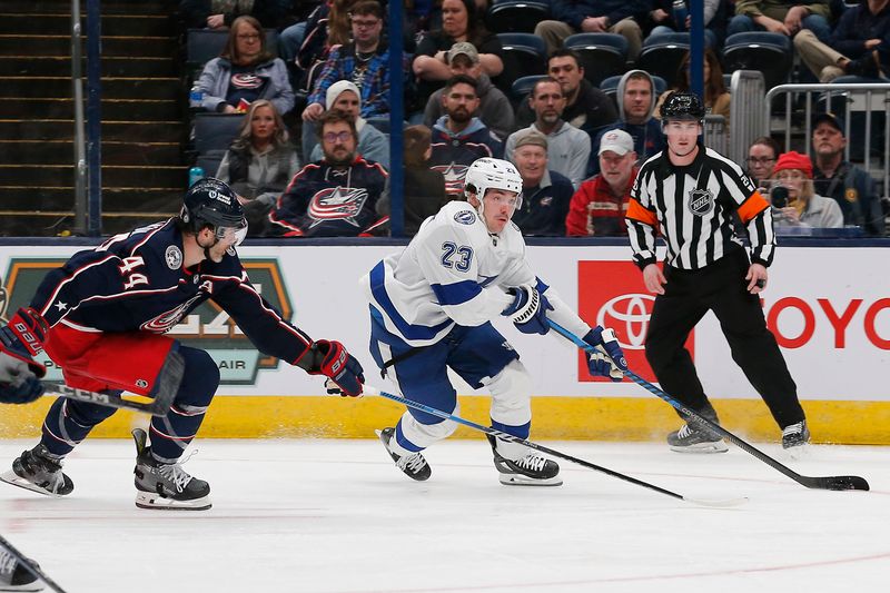 Feb 10, 2024; Columbus, Ohio, USA; Tampa Bay Lightning center Mikey Eyssimont (23) carries the puck past Columbus Blue Jackets defenseman Erik Gudbranson (44) during the third period at Nationwide Arena. Mandatory Credit: Russell LaBounty-USA TODAY Sports