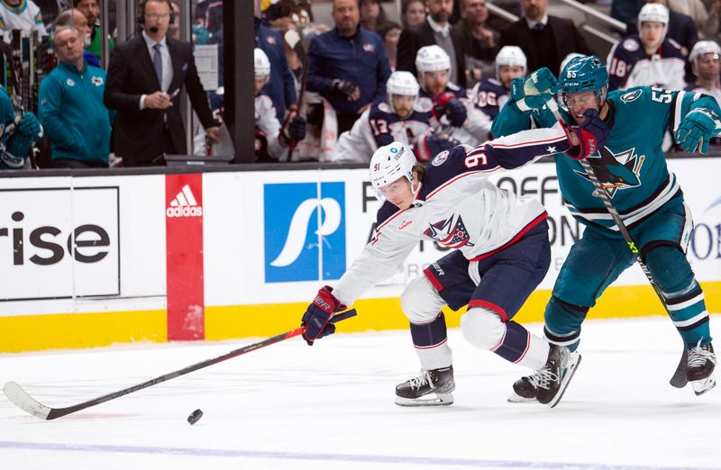 Mar 14, 2023; San Jose, California, USA; Columbus Blue Jackets center Kent Johnson (91) beats San Jose Sharks defenseman Derrick Pouliot (55) to the puck during the third period at SAP Center at San Jose. Mandatory Credit: D. Ross Cameron-USA TODAY Sports