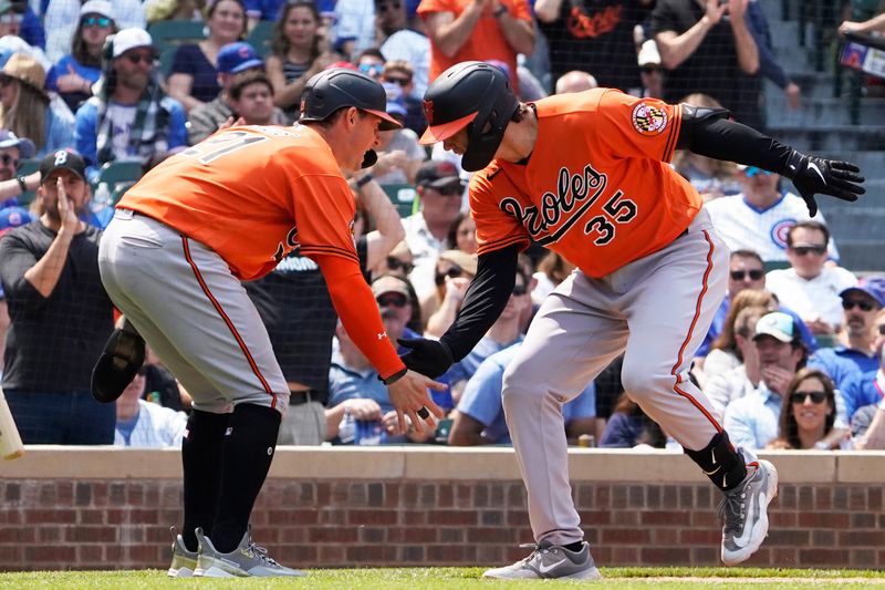 Jun 17, 2023; Chicago, Illinois, USA; Baltimore Orioles designated hitter  Adley Rutschman (35) is greeted by left fielder Austin Hays (21) after hitting a home run against the Chicago Cubs during the fifth inning at Wrigley Field. Mandatory Credit: David Banks-USA TODAY Sports