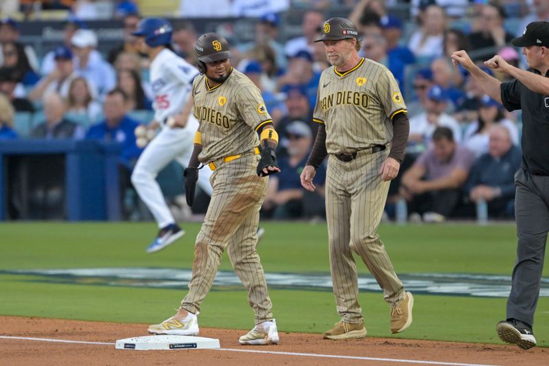 Oct 5, 2024; Los Angeles, California, USA; San Diego Padres first baseman Luis Arraez (4) hits a single in the first inning against the Los Angeles Dodgers during game one of the NLDS for the 2024 MLB Playoffs at Dodger Stadium. Mandatory Credit: Jayne Kamin-Oncea-Imagn Images