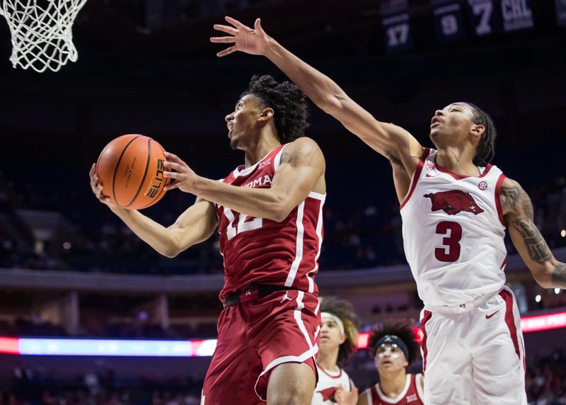 Dec 10, 2022; Tulsa, Oklahoma, USA; Oklahoma Sooners guard Milos Uzan (12) goes up for a shot as Arkansas Razorbacks guard Nick Smith Jr. (3) defends during the first half at BOK Center. Arkansas won 88-78. Mandatory Credit: Brett Rojo-USA TODAY Sports