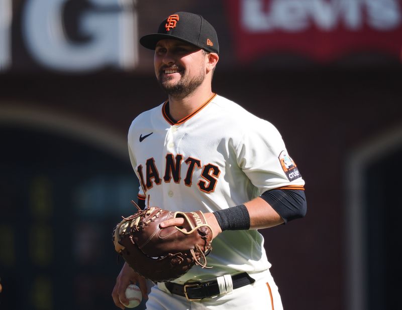 Aug 27, 2023; San Francisco, California, USA; San Francisco Giants first baseman J.D. Davis (7) smiles after making a play against the Atlanta Braves during the first inning at Oracle Park. Mandatory Credit: Kelley L Cox-USA TODAY Sports