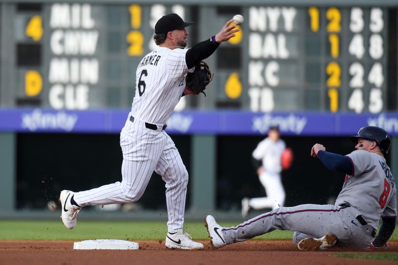 Apr 29, 2025; Denver, Colorado, USA; Colorado Rockies second base Kyle Farmer (6) turns a double play ahead of a slide by Atlanta Braves outfielder Alex Verdugo (8) during the first inning at Coors Field. Mandatory Credit: Christopher Hanewinckel-Imagn Images