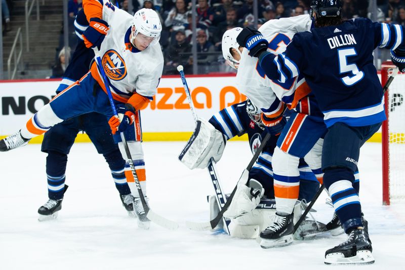 Jan 16, 2024; Winnipeg, Manitoba, CAN; New York Islanders forward Anders Lee (27) and New York Islanders forward Bo Horvat (14) look for a rebound from Winnipeg Jets goalie Connor Hellebuyck (37) during the first period at Canada Life Centre. Mandatory Credit: Terrence Lee-USA TODAY Sports