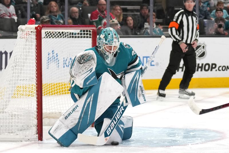 Jan 4, 2025; San Jose, California, USA; San Jose Sharks goaltender Yaroslav Askarov (30) makes a save against the New Jersey Devils during the first period at SAP Center at San Jose. Mandatory Credit: Darren Yamashita-Imagn Images