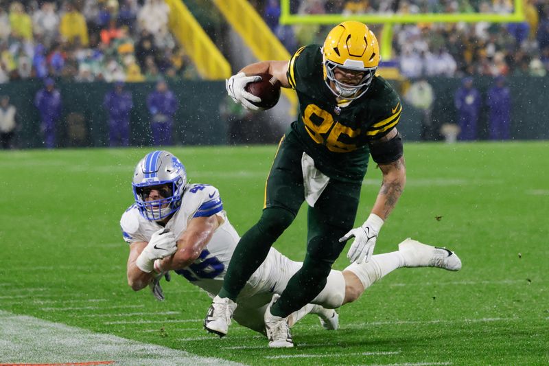 Green Bay Packers tight end Tucker Kraft (85) makes a catch past Detroit Lions linebacker Jack Campbell during the second half of an NFL football game Sunday, Nov. 3, 2024, in Green Bay, Wis. (AP Photo/Matt Ludtke)