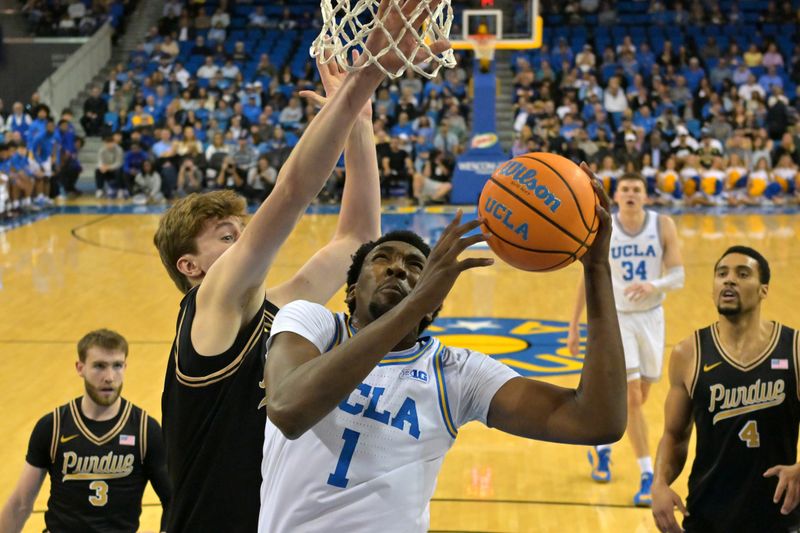 Jan 20, 2026; Los Angeles, California, USA;  UCLA Bruins forward Xavier Booker (1) drives ast Purdue Boilermakers center Daniel Jacobsen (12) in the first half at Pauley Pavilion presented by Wescom Financial. Mandatory Credit: Jayne Kamin-Oncea-Imagn Images