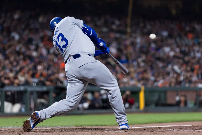 May 15, 2024; San Francisco, California, USA; Los Angeles Dodgers third baseman Max Muncy (13) hits a sacrifice fly for an RBI against the San Francisco Giants during the eighth inning at Oracle Park. Mandatory Credit: John Hefti-USA TODAY Sports