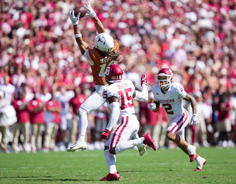 Oct 7, 2023; Dallas, Texas, USA; Texas Longhorns wide receiver Jordan Whittington (13) drops the football against Oklahoma Sooners defensive back Kendel Dolby (15) and defensive back Billy Bowman Jr. (2) in the fourth quarter at the Cotton Bowl. This game makes up the 119th rivalry match up. Mandatory Credit: Ricardo B. Brazziell-USA TODAY Sports