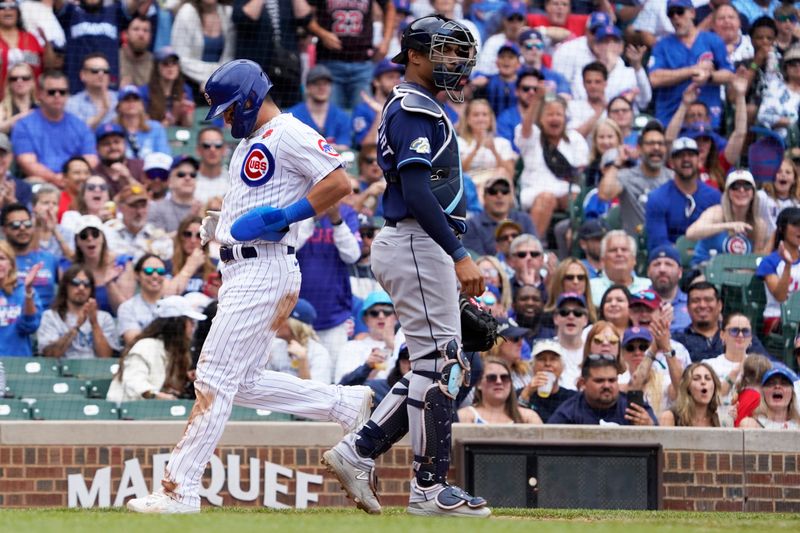 May 29, 2023; Chicago, Illinois, USA; Chicago Cubs right fielder Seiya Suzuki (27) scores as Tampa Bay Rays catcher Christian Bethancourt (14) stands nearby during the fourth inning at Wrigley Field. Mandatory Credit: David Banks-USA TODAY Sports