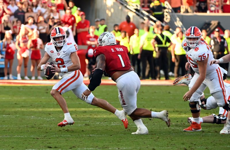 Oct 28, 2023; Raleigh, North Carolina, USA; Clemson Tigers quarterback Cade Klubnik (2) scrambles as North Carolina State Wolfpack defensive end Davin Vann (1) pursues during the second half at Carter-Finley Stadium.  The Wolfpack won 24-17. Mandatory Credit: Rob Kinnan-USA TODAY Sports