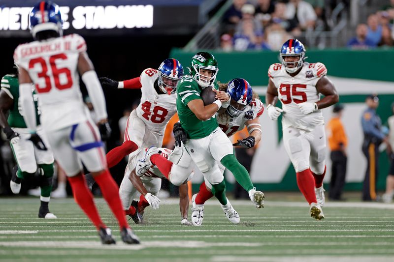 New York Jets quarterback Adrian Martinez (15) runs with the ball during a preseason NFL football game against the New York Giants Saturday, Aug. 24, 2024, in East Rutherford, N.J. (AP Photo/Adam Hunger)