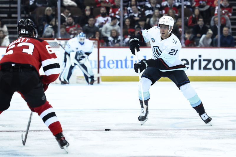 Feb 12, 2024; Newark, New Jersey, USA; Seattle Kraken center Alex Wennberg (21) skates with the puck against as New Jersey Devils left wing Jesper Bratt (63) defends during the first period at Prudential Center. Mandatory Credit: John Jones-USA TODAY Sports