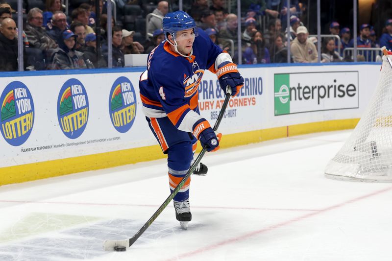 Jan 25, 2025; Elmont, New York, USA; New York Islanders defenseman Tony DeAngelo (4) looks to pass the puck against the Carolina Hurricanes during the second period at UBS Arena. Mandatory Credit: Brad Penner-Imagn Images