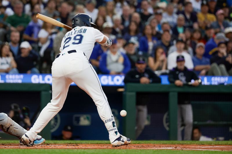 Sep 23, 2025; Seattle, Washington, USA; Seattle Mariners catcher Cal Raleigh (29) is hit in the foot by a pitch against the Colorado Rockies during the first inning at T-Mobile Park. Mandatory Credit: Joe Nicholson-Imagn Images