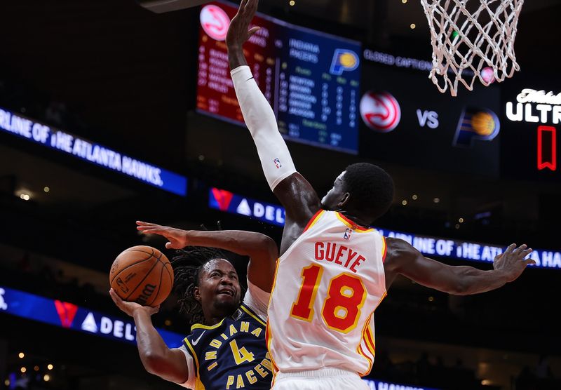 ATLANTA, GEORGIA - OCTOBER 08:  Tristen Newton #4 of the Indiana Pacers attempts a shot against Mouhamed Gueye #18 of the Atlanta Hawks during the fourth quarter at State Farm Arena on October 08, 2024 in Atlanta, Georgia.  NOTE TO USER: User expressly acknowledges and agrees that, by downloading and/or using this photograph, user is consenting to the terms and conditions of the Getty Images License Agreement.  (Photo by Kevin C. Cox/Getty Images)