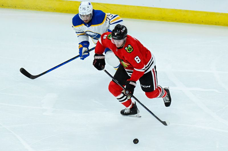 Oct 19, 2024; Chicago, Illinois, USA;  Chicago Blackhawks center Ryan Donato (8) moves the puck against Buffalo Sabres defenseman Connor Clifton (75) during the third period at the United Center. Mandatory Credit: Matt Marton-Imagn Images