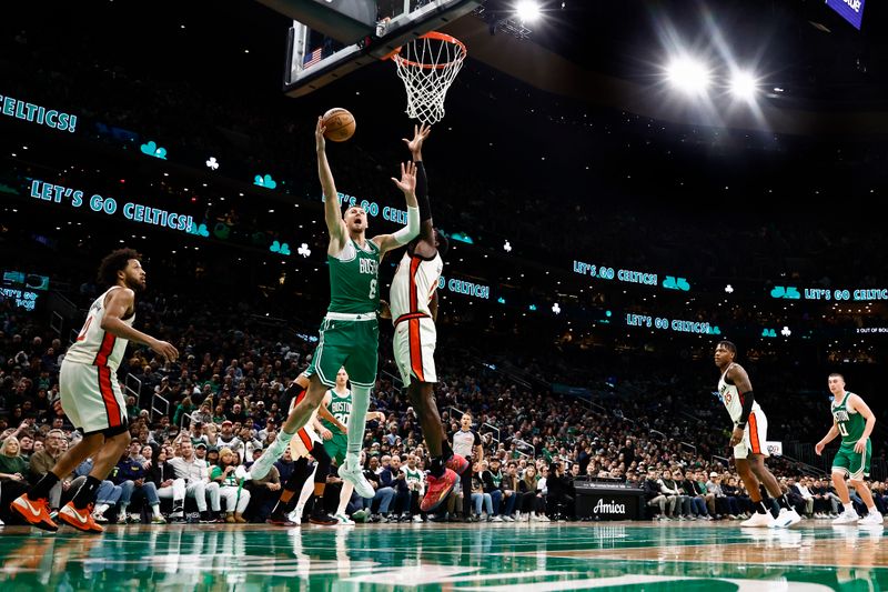 BOSTON, MA - DECEMBER 4: Kristaps Porzingis #8 of the Boston Celtics goes to the basket against Jalen Duren #0 of the Detroit Pistons during the second half at TD Garden on December 4, 2024 in Boston, Massachusetts. NOTE TO USER: User expressly acknowledges and agrees that, by downloading and/or using this Photograph, user is consenting to the terms and conditions of the Getty Images License Agreement. (Photo By Winslow Townson/Getty Images)