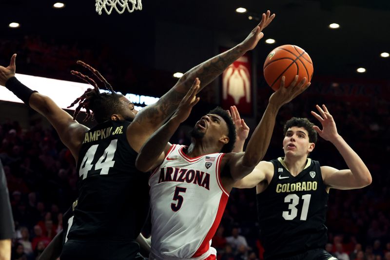 Jan 4, 2024; Tucson, Arizona, USA; Arizona Wildcats guard KJ Lewis (5) shoots a basket against Colorado Buffaloes center Eddie Lampkin Jr. (44) and guard Harrison Carrington (31) during the second half at McKale Center. Mandatory Credit: Zachary BonDurant-USA TODAY Sports