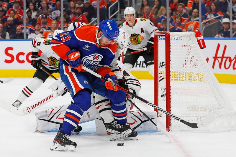 Oct 12, 2024; Edmonton, Alberta, CAN; Edmonton Oilers /forward Mattias Janmark (13) looks for a loose puck in front of Chicago Blackhawks goaltender Petr Mrazek (34) during the first period at Rogers Place. Mandatory Credit: Perry Nelson-Imagn Images