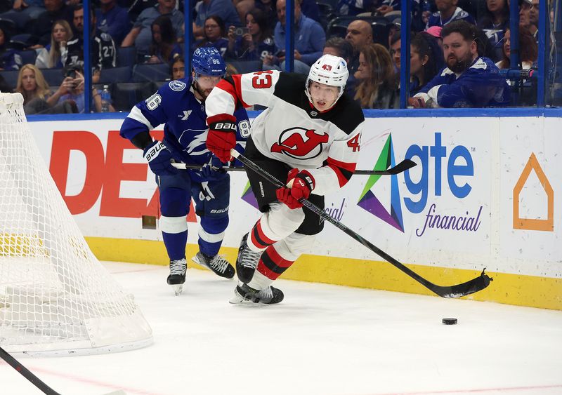 Nov 18, 2025; Tampa, Florida, USA; New Jersey Devils defenseman Luke Hughes (43) skates with the puck as Tampa Bay Lightning right wing Nikita Kucherov (86) defends during the third period at Benchmark International Arena. Mandatory Credit: Kim Klement Neitzel-Imagn Images
