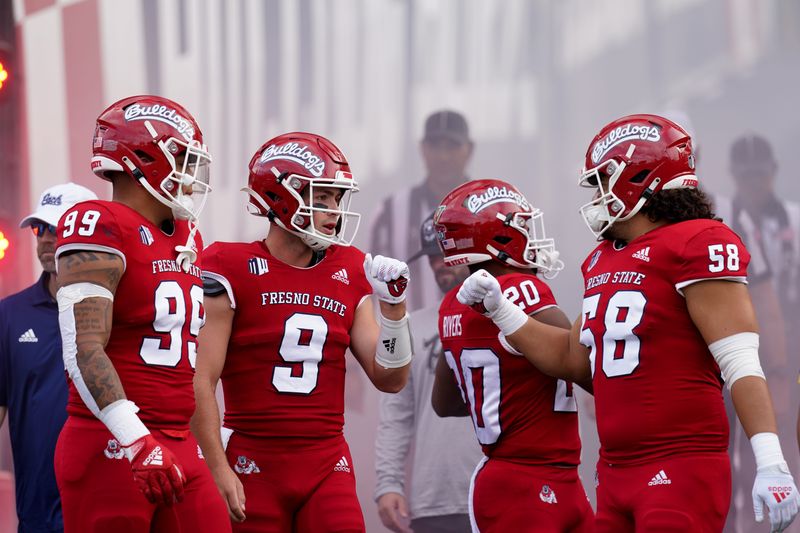 Oct 23, 2021; Fresno, California, USA; Fresno State Bulldogs quarterback Jake Haener (9) talks with teammates before a game against the Nevada Wolf Pack at Bulldog Stadium. Mandatory Credit: Cary Edmondson-USA TODAY Sports