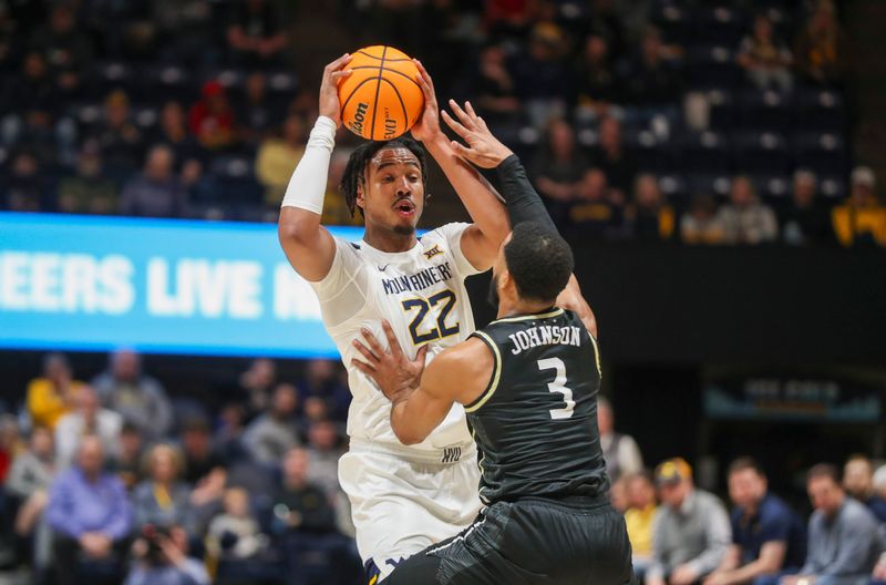 Feb 20, 2024; Morgantown, West Virginia, USA; West Virginia Mountaineers forward Josiah Harris (22) looks to pass while defended by UCF Knights guard Darius Johnson (3) during the second half at WVU Coliseum. Mandatory Credit: Ben Queen-USA TODAY Sports