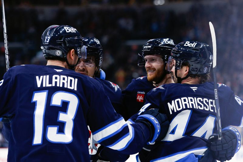 Mar 14, 2025; Winnipeg, Manitoba, CAN;  Winnipeg Jets forward Kyle Connor (81) is congratulated by his team mates on his goal against the Dallas Stars during the second period at Canada Life Centre. Mandatory Credit: Terrence Lee-Imagn Images