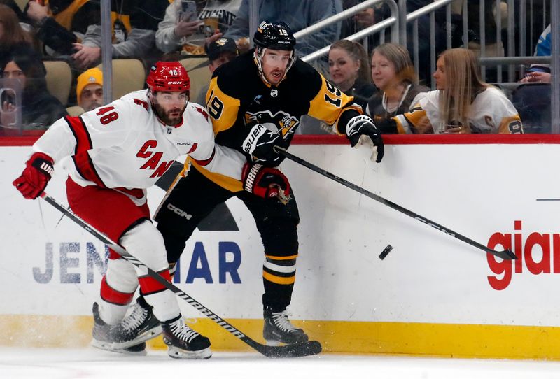 Mar 26, 2024; Pittsburgh, Pennsylvania, USA; Carolina Hurricanes left wing Jordan Martinook (48) and Pittsburgh Penguins right wing Reilly Smith (19) chase the puck during the first period at PPG Paints Arena. Mandatory Credit: Charles LeClaire-USA TODAY Sports