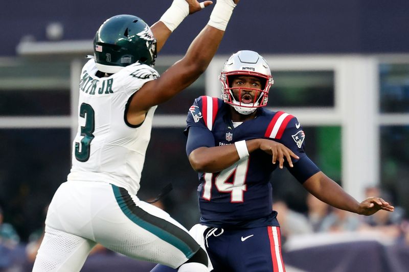 New England Patriots quarterback Jacoby Brissett (14) passes under pressure from Philadelphia Eagles linebacker Nolan Smith Jr. (3) during the first half of an NFL preseason football game, Thursday, Aug. 15, 2024, in Foxborough, Mass. (AP Photo/Mark Stockwell)