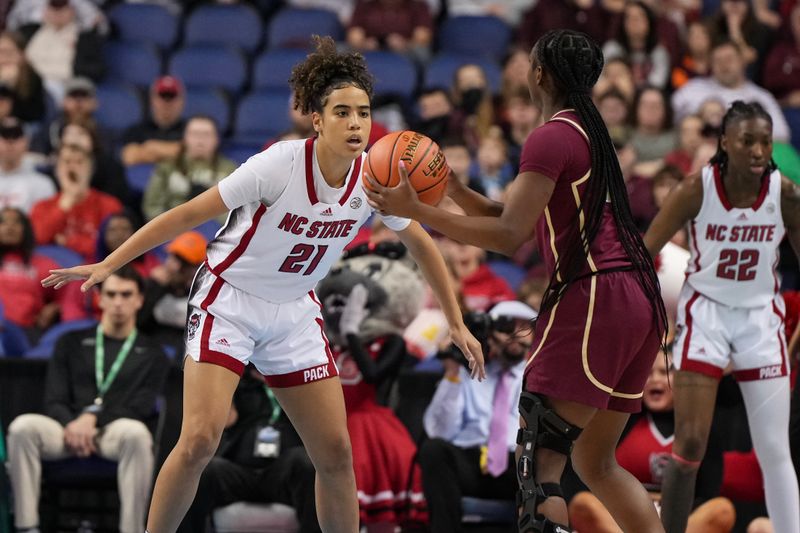 Mar 9, 2024; Greensboro, NC, USA; NC State Wolfpack guard Madison Hayes (21) defends Florida State Seminoles guard Ta'Niya Latson (00) in the first half at Greensboro Coliseum. Mandatory Credit: David Yeazell-USA TODAY Sports