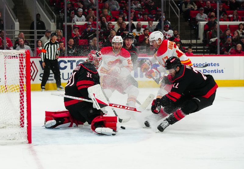 Mar 10, 2024; Raleigh, North Carolina, USA;  Carolina Hurricanes goaltender Frederik Andersen (31) stops the shot by Calgary Flames center Kevin Rooney (21) during the second period at PNC Arena. Mandatory Credit: James Guillory-USA TODAY Sports