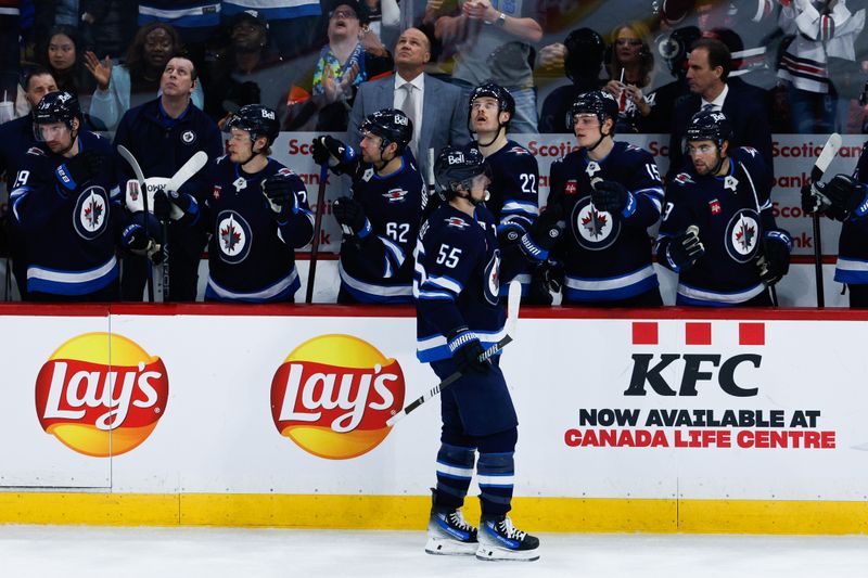 Jan 26, 2025; Winnipeg, Manitoba, CAN;  Winnipeg Jets forward Mark Scheifele (55) is congratulated by his team mates on his goal against the Calgary Flames during the third period at Canada Life Centre. Mandatory Credit: Terrence Lee-Imagn Images