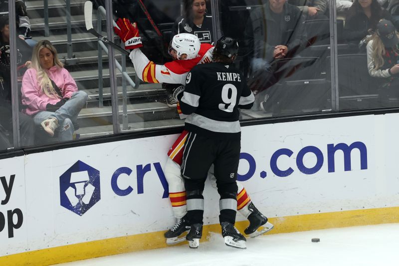 Dec 13, 2025; Los Angeles, California, USA;  Los Angeles Kings right wing Adrian Kempe (9) hits Calgary Flames defenseman Kevin Bahl (7) to the boards while playing for the puck during the third period at Crypto.com Arena. Mandatory Credit: Kiyoshi Mio-Imagn Images