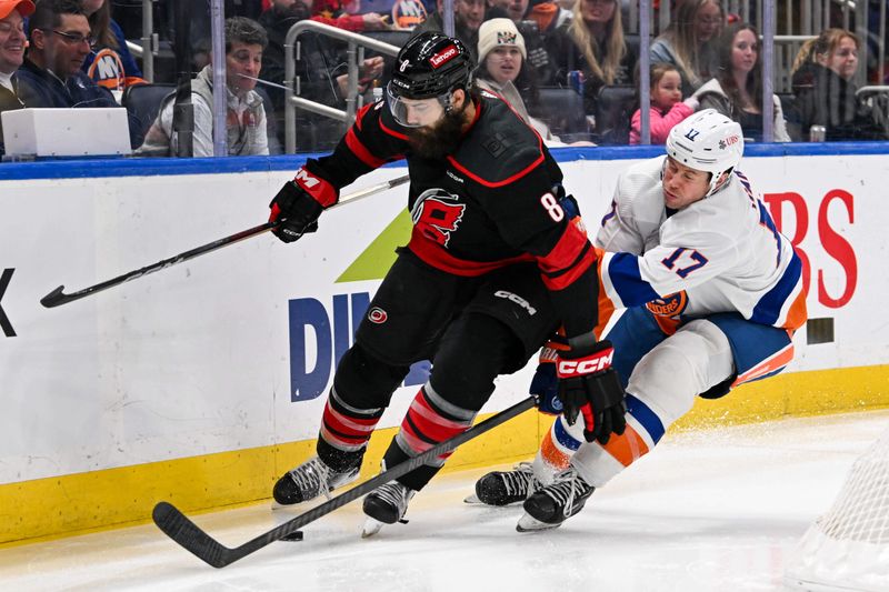 Mar 19, 2024; Elmont, New York, USA; New York Islanders left wing Matt Martin (17) chases Carolina Hurricanes defenseman Brent Burns (8) behind the net during the second period at UBS Arena. Mandatory Credit: Dennis Schneidler-USA TODAY Sports